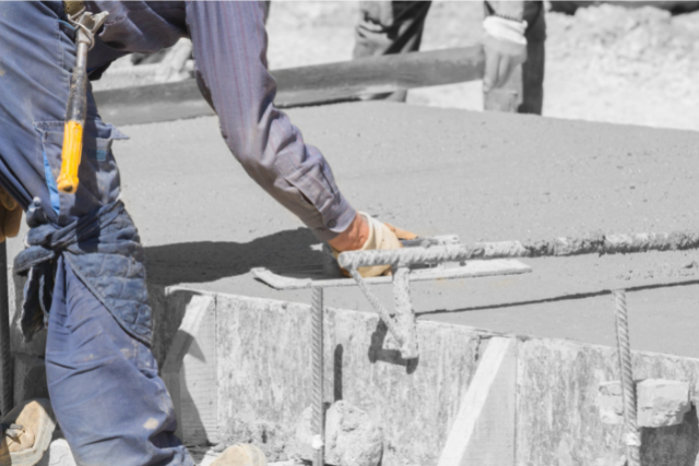 Construction workers leveling concrete pavement